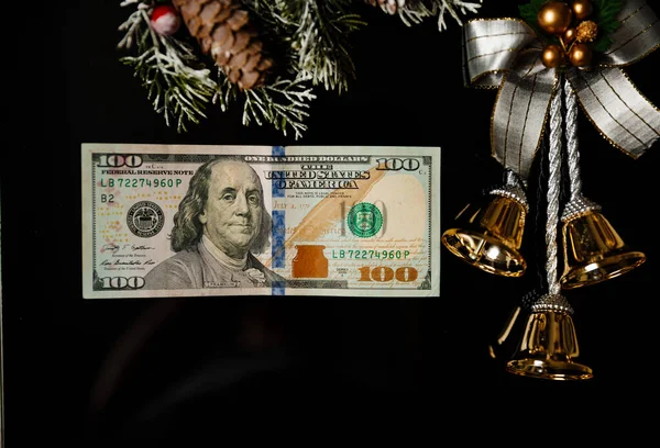 Festive New year Christmas bell and one hundred American dollar bill on black background — Stock Photo, Image