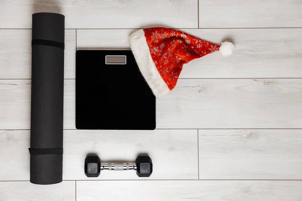 グレーの木製の背景に黒の重量、マットとダンベル。クリスマスのコンセプト — ストック写真