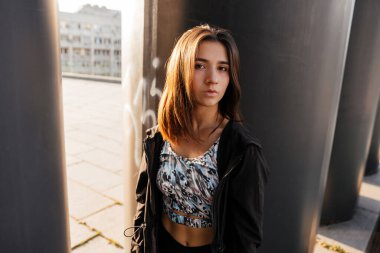Karanlık bir şehir geçmişinde spor giyimli genç bir kızın portresi.