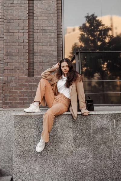 Großes stylisches Mädchen mit überdimensionaler Jacke posiert am Geländer und tritt auf den Hintergrund der Stadt — Stockfoto