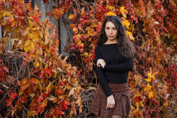 Закрыть портрет молодой брюнетки на фоне бургундского осеннего пейзажа — стоковое фото