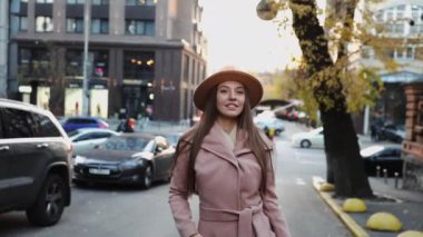  Paltolu ve şapkalı çekici genç bir kadın sokakta yürüyor.
