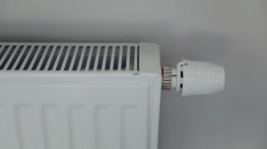 Yakın plan. El ısıtma radyatörünün termostatını açar.