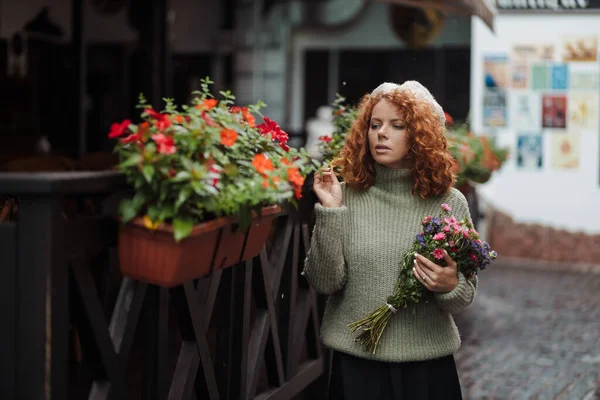 Γυναίκα πορτρέτο σε ένα μπερέ πουλόβερ κρατώντας ένα μπουκέτο λουλούδια του εστιατορίου φόντο — Φωτογραφία Αρχείου