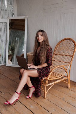 Sevimli ve mutlu uzun saçlı esmer kadın bir bungalovda çalışıyor.