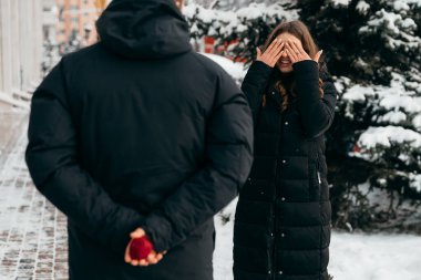 Evlilik teklifinden önce bir dakika beklemek. Adam elinde yüzükle uyku tulumunu tutuyor.