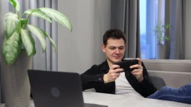 Cep telefonu çalan adam. Erkek kapalı alanda video oyunu oynamak için telefon kullanıyor