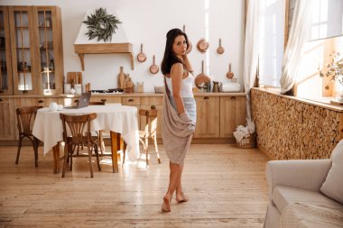 Modern evlerin ahşap zemininde, ısıtmalı zeminde yürüyen bir kadın.