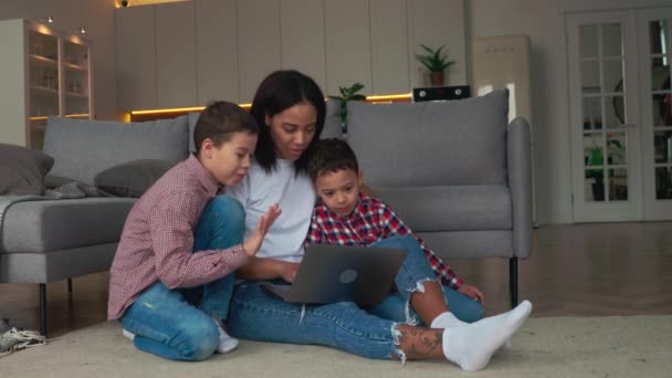 Mãe e dois filhos fazendo uma chamada de vídeo com seus parentes por laptop — Vídeo de Stock