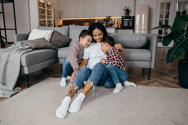 Young afro american mom hugs her beloved two sons tenderly — Stock Photo, Image