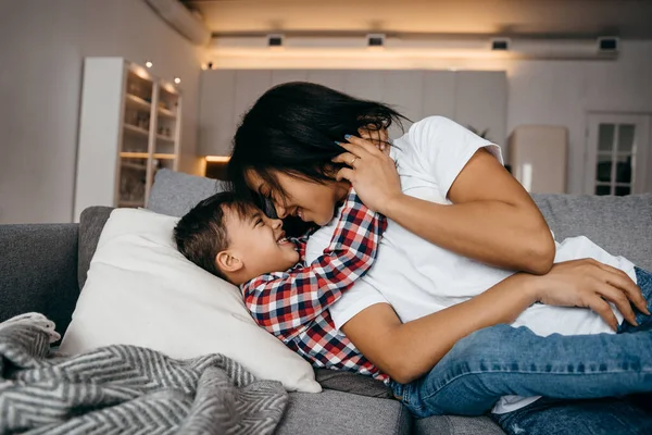 Joven afro-americana mamá abraza tiernamente a su amado hijo —  Fotos de Stock