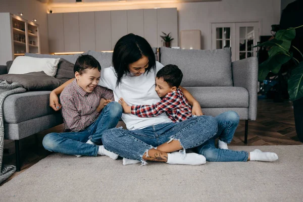 Young afro american mom hugs her beloved two sons tenderly — Stock Photo, Image