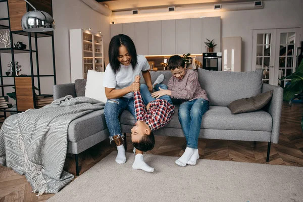 Feliz africano americano familia mamá y dos hijos jugando alrededor y divertirse en casa juntos —  Fotos de Stock