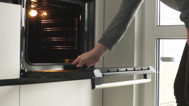 Yemek pişirdikten sonra elektrikli fırını temizleyen kadın — Stok video