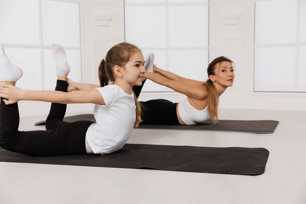 Mãe e filha criança no centro de ginástica fazendo alongamento aptidão Yoga exercício — Fotografia de Stock