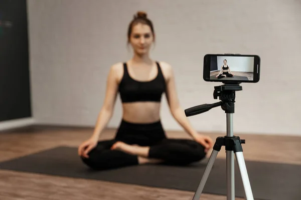 Jovem blogueira com câmera no estúdio de ioga online de gravação de tripé — Fotografia de Stock