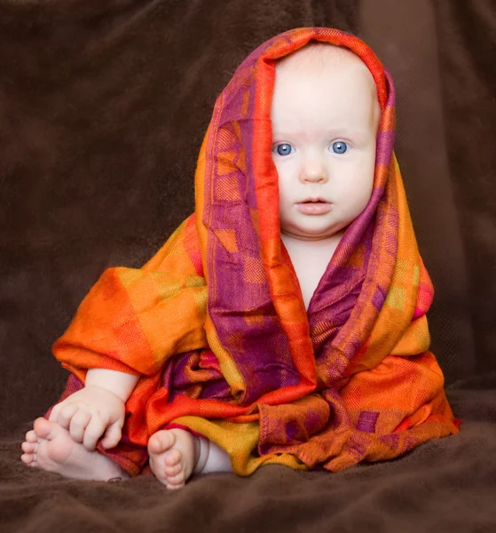 Meisje van de baby verpakt in een oranje sjaal — Stockfoto