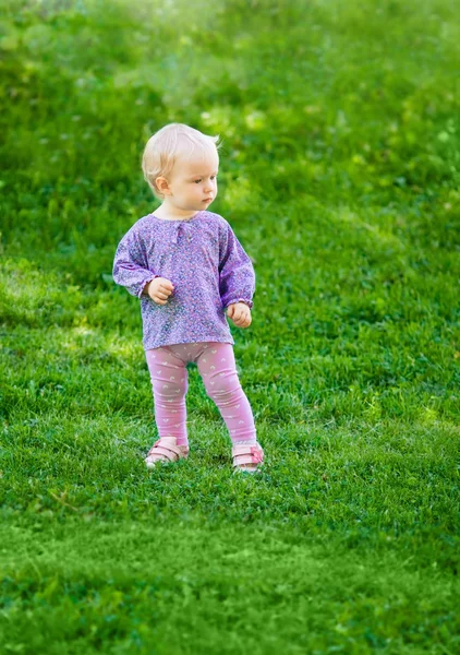 Bonito engraçado bebê menina na grama — Fotografia de Stock