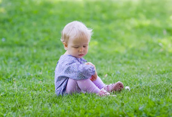 Söt baby sitter på ängen — Stockfoto