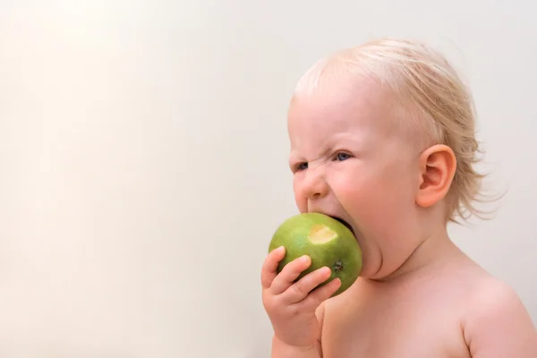 Funny baby eten apple — Stockfoto