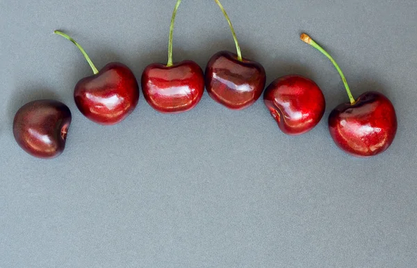 Cerezas en gris, copyspace, tarjeta — Foto de Stock