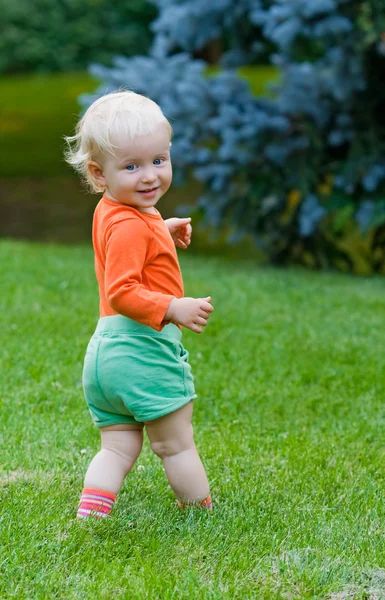 Smilende baby står utendørs – stockfoto