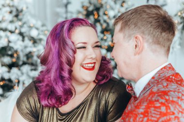 LGBTQ lezbiyen çifti Noel 'i veya yeni yılı birlikte kutluyorlar. Eşcinsel kadın ve erkek partneri evdeki kanepede sarılıyorlar. Kış tatili ruhu. Birbirine aşık çift