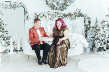 LGBTQ lezbiyen çifti Noel 'i yeni yıl kış tatilini kutluyor. Erkeksi eşi olan eşcinsel bir kadın Noel arifesinde birbirlerine hediye kutuları veriyor.