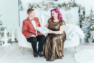 LGBTQ lezbiyen çifti Noel 'i yeni yıl kış tatilini kutluyor. Erkeksi eşi olan eşcinsel bir kadın Noel arifesinde birbirlerine hediye kutuları veriyor.