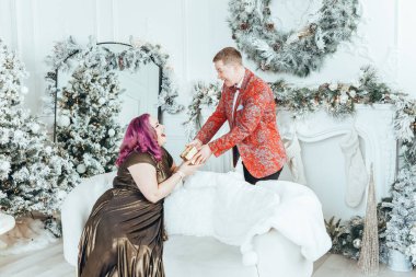 LGBTQ lezbiyen çifti Noel 'i yeni yıl kış tatilini kutluyor. Erkeksi eşi olan eşcinsel bir kadın Noel arifesinde birbirlerine hediye kutuları veriyor.