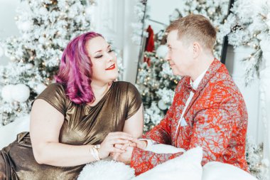 LGBTQ lezbiyen çifti Noel 'i veya yeni yılı birlikte kutluyorlar. Erkeksi partnerli eşcinsel kadın evde sarılıp el ele tutuşuyor. Kış tatili ruhu. Birbirine aşık çift.