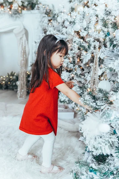 Anak Gadis Balita Asia Dengan Gaun Merah Yang Menghias Pohon — Stok Foto