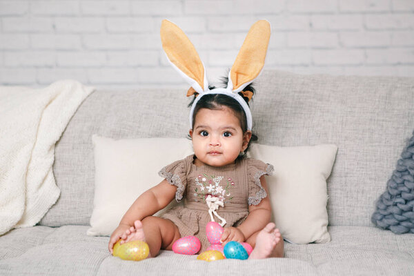 Cute Indian Baby Girl Pink Bunny Ears Playing Colorful Eggs Stock Image