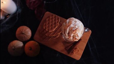 Cadılar Bayramı Lattesi. Cadılar Bayramı dekorasyonunda balkabağı aromalı kahve. Krem şantili balkabağı aromalı latte ve taze tarçın. Yukarı Aşağı Görünüm