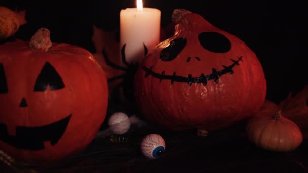 Pequenas abóboras assustadoras sorrisos assustados. Abóboras de Halloween configuradas. Decorações de Halloween na mesa. — Vídeo de Stock