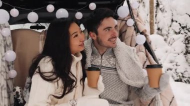 Tatlı bir çift, Kış Ormanı pikniğinde çay içiyorlar. Doğa pikniği. Arabadaki Aşk Hikayesi.