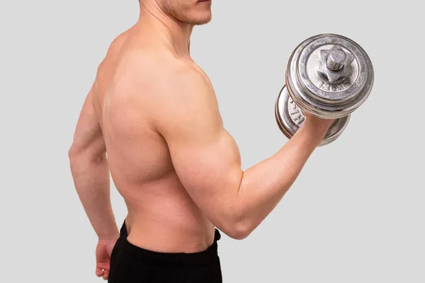 Hombre en topless bombeando bíceps con mancuerna. Sprotsman haciendo entrenamiento en músculos bíceps. Gimnasio, Lifting Sport Concept. Primer plano — Foto de Stock