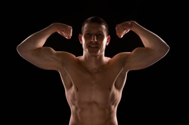 Adam Pazıları Gösteriyor. Eller yukarı. Sporcu Kaslarını Gösteriyor. ABS, kas gücü. Rim Işığı