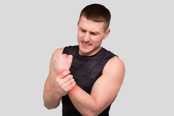 Uomo sportivo che tiene il polso. Uomo ferito. Uomo sportivo Ferita da polso. Macchia rossa sulla parte del dolore. — Foto Stock