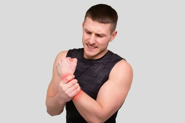 Hombre del deporte sosteniendo la muñeca. Hombre con lesiones. Hombre Deportivo Lesión de muñeca. Mancha roja en la parte herida. —  Fotos de Stock