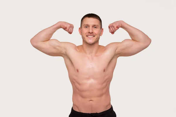 De man die Biceps handen omhoog laat zien. Sportman toont spierballen. ABS, Biceps Spieren. Geïsoleerde mens — Stockfoto