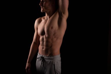 ABS 'yi gösteren adam. Kaslı adam pozu. Güçlü Vücut Kavramı. Üstsüz Spor Adamı Vücut Geliştirici. Altı Paket Gözlemcisi