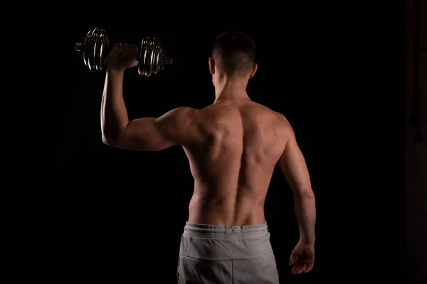 Sport man Standing with Dumbbell in Hand. Man Working out with Dumbbell. Sportsman Back View — Stock Photo, Image