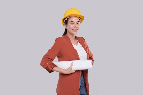 Girl Construction Worker Holding House Plan in Hands Watching at it. Girl Architect Holding Blueprints. Capacete duro amarelo. — Fotografia de Stock