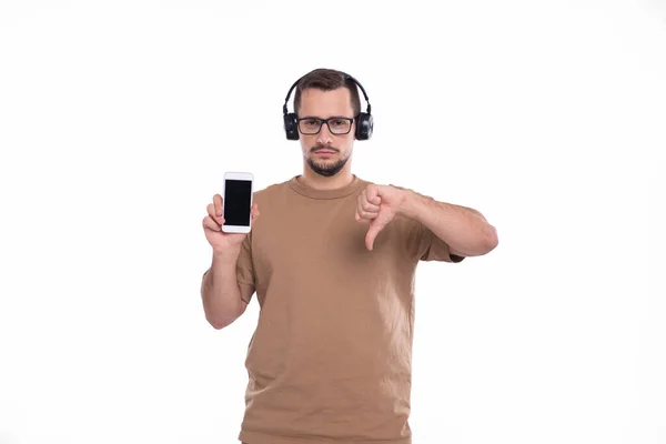 Man Listening to Music from Phone Mostrando o polegar para baixo. Homem apontando para tela verde do telefone. Isolados — Fotografia de Stock