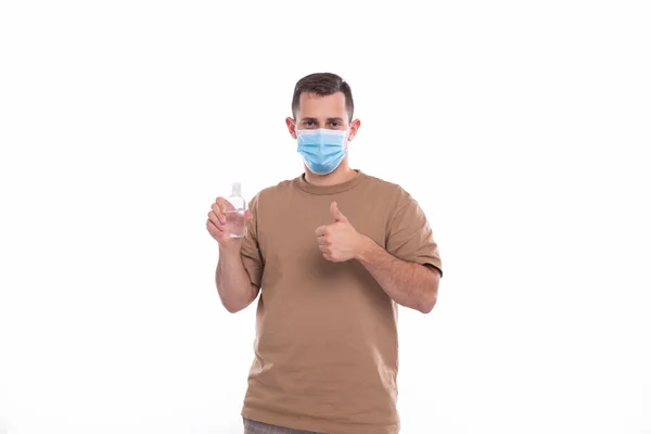 Άνδρας που κρατά τα χέρια Sanitizer φορώντας ιατρική μάσκα απομονωμένη — Φωτογραφία Αρχείου