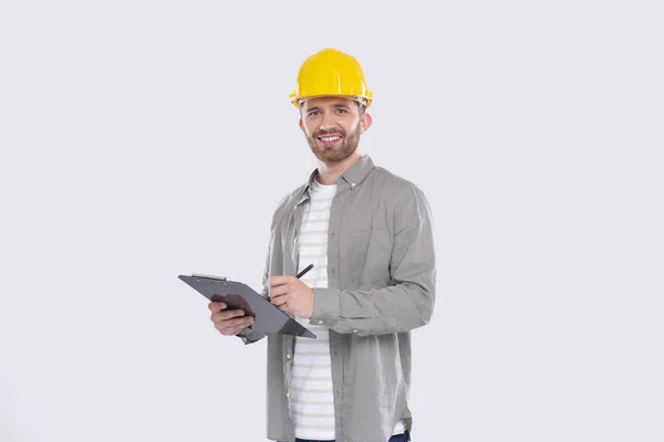 Man Construction Worker Skriva i Urklipp Titta i kameran isolerad. Man Builder Arbetar med Urklipp. Commecial, Shopping, Reklam koncept — Stockfoto