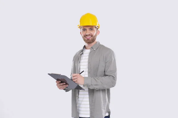 Homem trabalhador da construção escrevendo em área de transferência assistindo em câmera isolada. Homem Construtor Trabalhando com Clipboard. Conceito Commecial, Compras, Anúncio — Fotografia de Stock