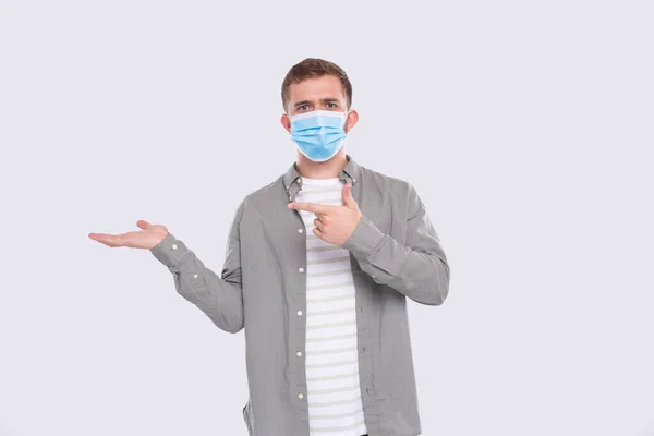 Man visar hand till sida pekar på det. Man bär medicinsk mask. Gesture Concept Isolerad — Stockfoto