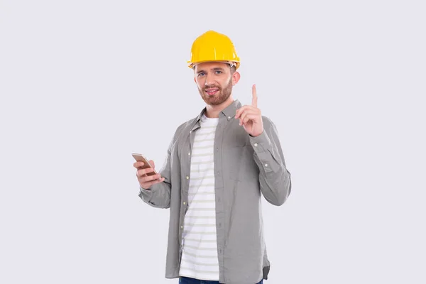 Trabalhador da construção civil ter uma grande ideia segurando o telefone em mãos. Homem com Idéia Segurando o Dedo. Trabalhador em Capacete duro isolado — Fotografia de Stock